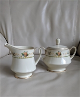 Noritake Normandy pattern cream porcelain footed creamer and lidded sugar bowl set with fruit floral motifs from the 1970s