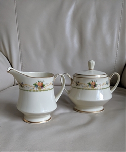 Noritake Normandy pattern cream porcelain footed creamer and lidded sugar bowl set with fruit floral motifs from the 1970s
