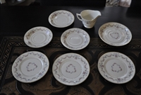 Eight piece vintage Arcadia by Syracuse Old Ivory porcelain set featuring floral swags and gold accents including plates saucers and a creamer