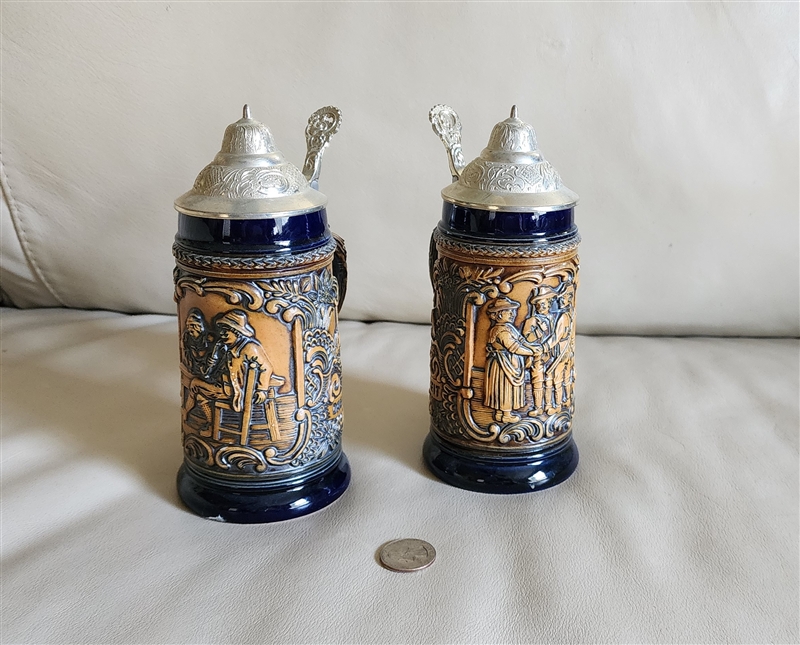 Matching pair of authentic Germany high relief tavern scene beer steins with grey pewter lids