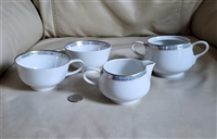 Vintage four piece Rosenthal Continental Ice Blue German porcelain tea set featuring a creamer open double handled sugar bowl and two teacups with light blue and gold borders