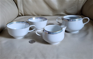 Vintage four piece Rosenthal Continental Ice Blue German porcelain tea set featuring a creamer open double handled sugar bowl and two teacups with light blue and gold borders