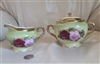 O and EG Royal Austria antique porcelain lidded sugar bowl and creamer set in green with hand-painted roses and gold trim from the 1900s