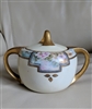 antique white porcelain lidded sugar bowl with Art Nouveau floral decor heavy gold handles and ornate lid finial from the 1910s
