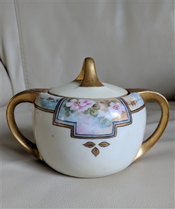 antique white porcelain lidded sugar bowl with Art Nouveau floral decor heavy gold handles and ornate lid finial from the 1910s