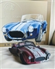 preowned Jada Toys 1965 Shelby Cobra 427 SC car model and 1966 Shelby Cobra tin sign modern display