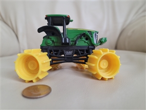 Vintage John Deere mini road roller toy with green metal top and black plastic undercarriage