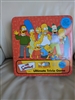 The Simpsons Ultimate Trivia Game with a tin box and poster game night accessories poster