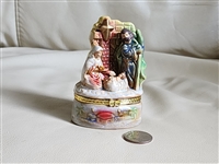 Colorful porcelain nativity scene trinket box showing Mary Joseph and baby Jesus with gold tone metal accents